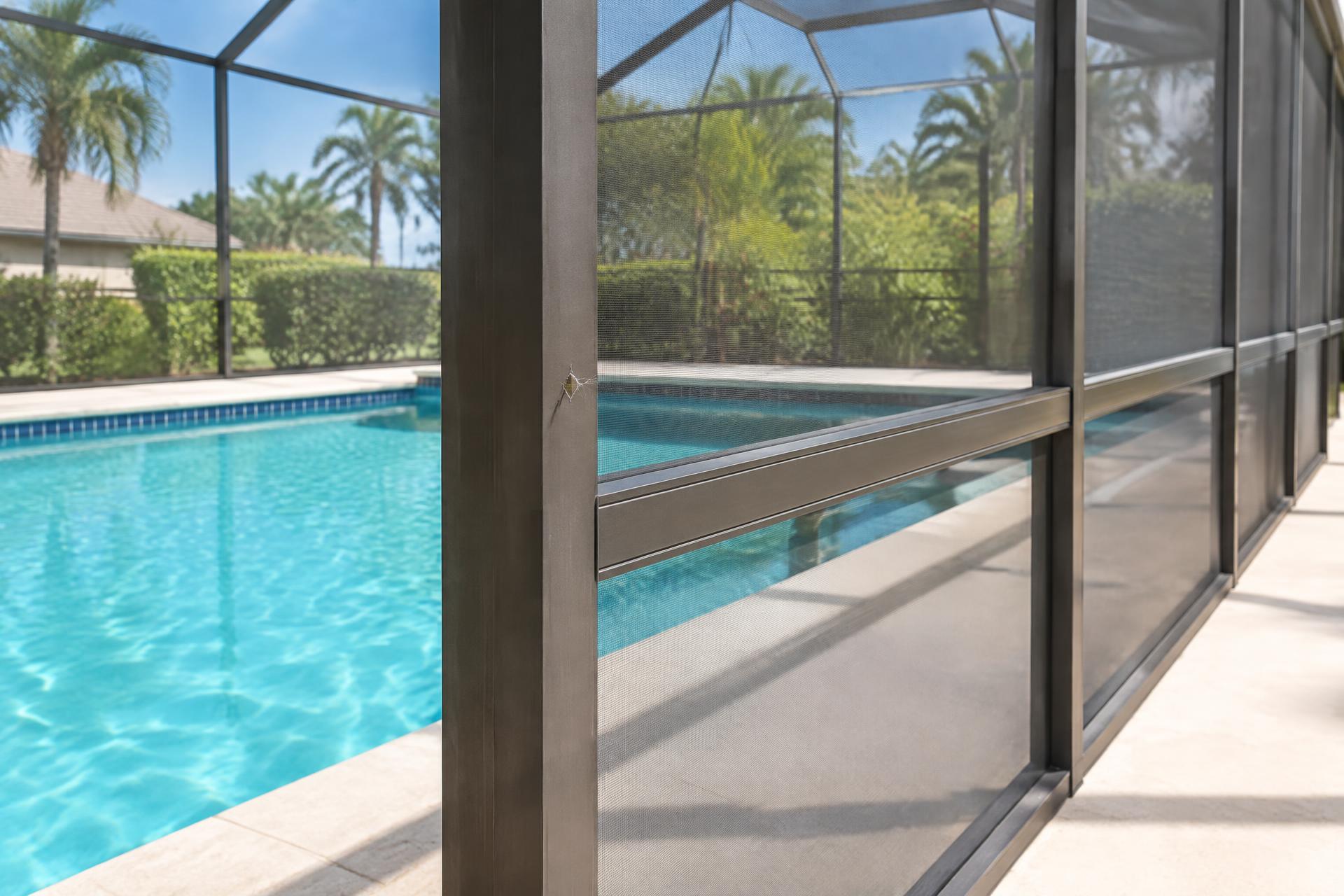 Pool enclosure mesh beside the water with a small localized opening